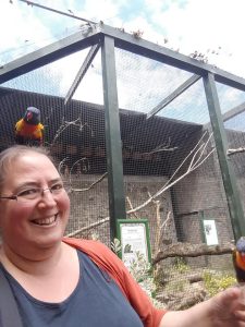 image showing counsellor Sarah watso n with a parrot on her head.